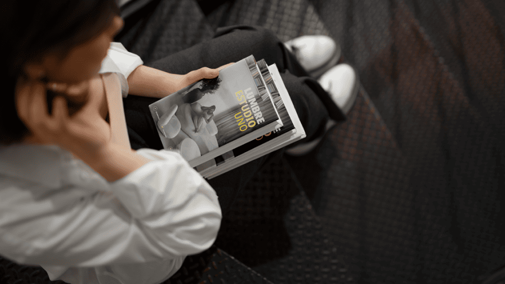 Persona sosteniendo una revista de diseño editorial, ejemplo de maquetación gráfica moderna y composición tipográfica equilibrada.