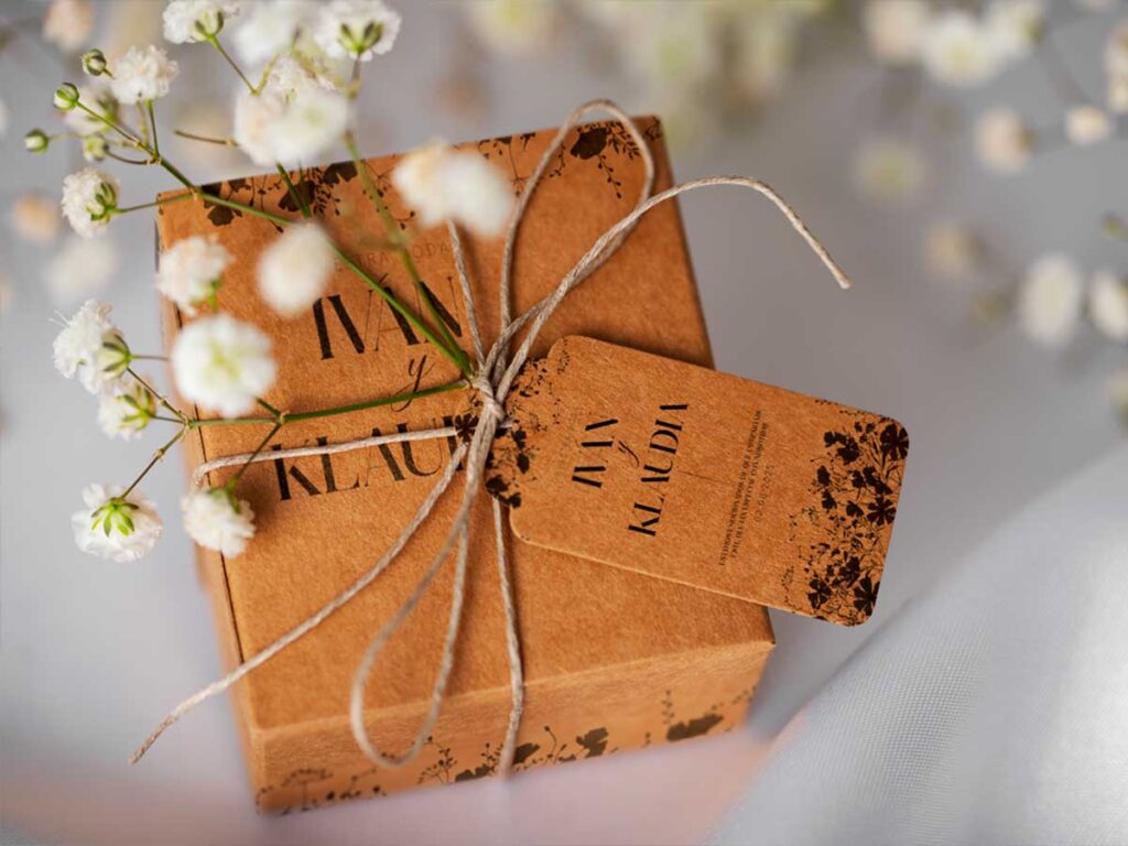 Caja de regalo para invitados de boda con etiqueta personalizada y cuerda natural, diseño de packaging nupcial elegante y artesanal.