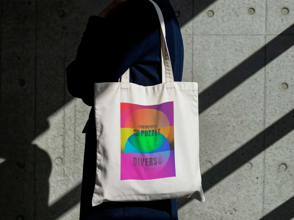 Tote bag con estampado colorido de mensaje inclusivo, ejemplo de merchandising de campaña LGTBIQ+.